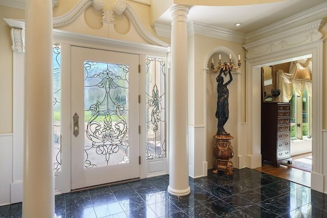 tiled entrance foyer featuring decorative columns and ornamental molding