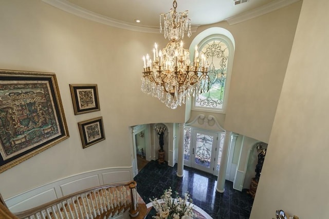 foyer with a notable chandelier, dark wood-type flooring, and ornamental molding