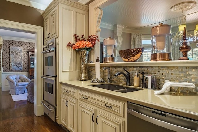 kitchen with cream cabinetry, dark wood-type flooring, sink, crown molding, and dishwashing machine