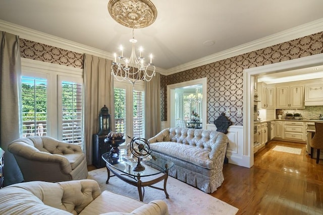 living room with a notable chandelier, crown molding, and hardwood / wood-style floors