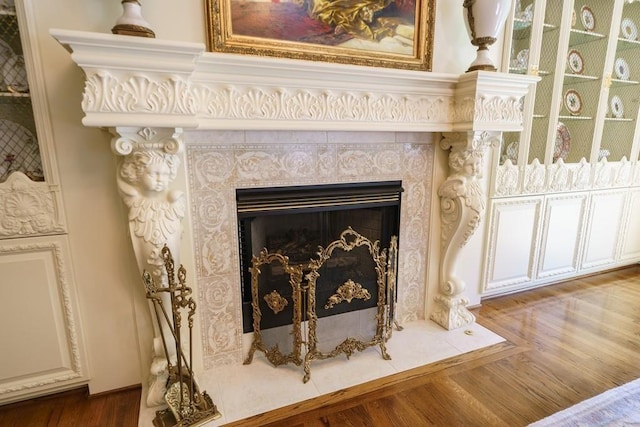 interior details with a tile fireplace and dark wood-type flooring