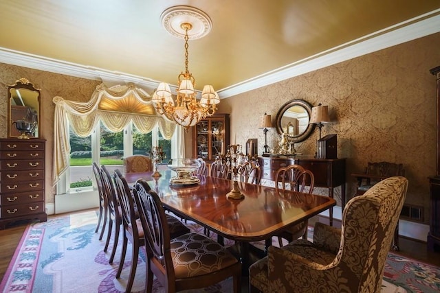 dining space featuring crown molding, a chandelier, and hardwood / wood-style flooring