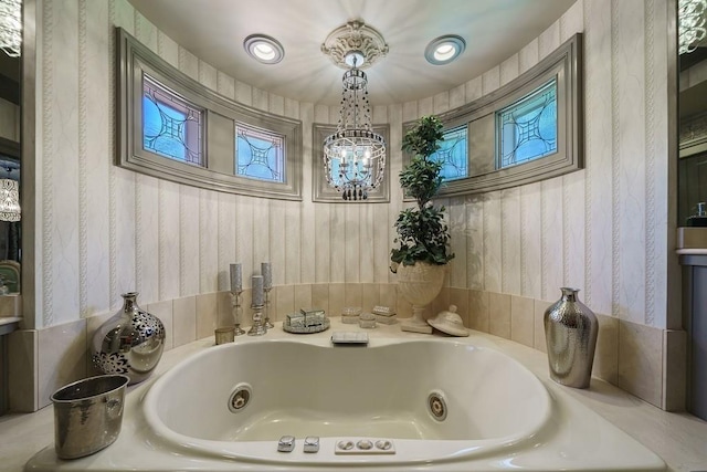 bathroom with an inviting chandelier and a bathing tub