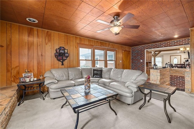 living room with ceiling fan, brick wall, wood walls, and carpet