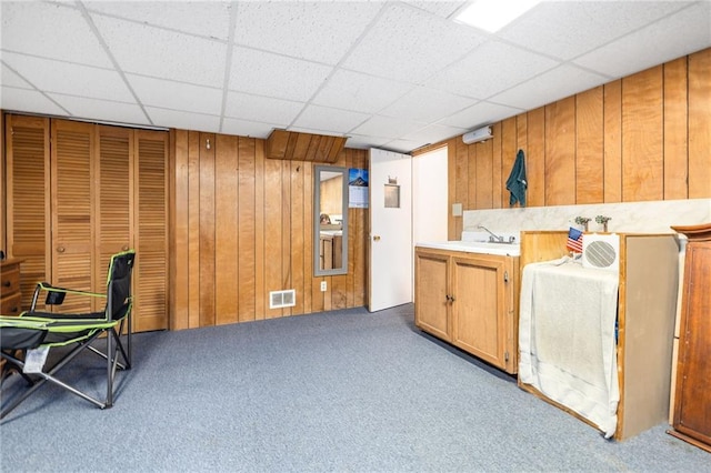 interior space featuring wood walls, carpet, and visible vents