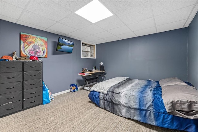 bedroom featuring carpet, a paneled ceiling, and baseboards