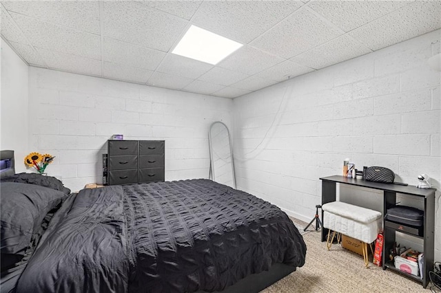 bedroom featuring concrete block wall