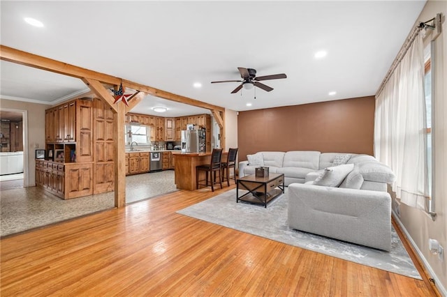 living area with crown molding, light wood-type flooring, ceiling fan, and recessed lighting