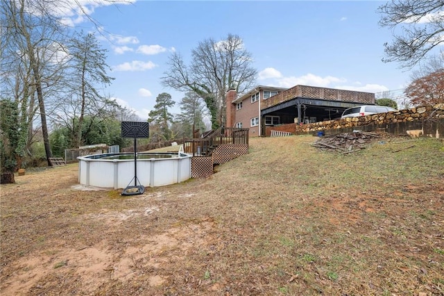 view of yard featuring an outdoor pool and a wooden deck