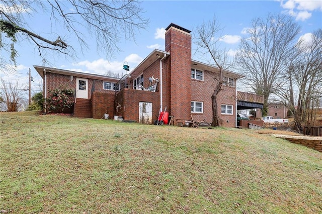 rear view of property with brick siding, a lawn, and a chimney