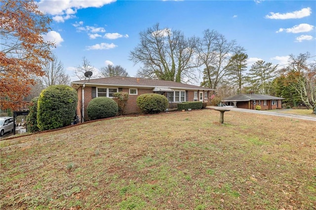 ranch-style home with a carport, a front lawn, and brick siding