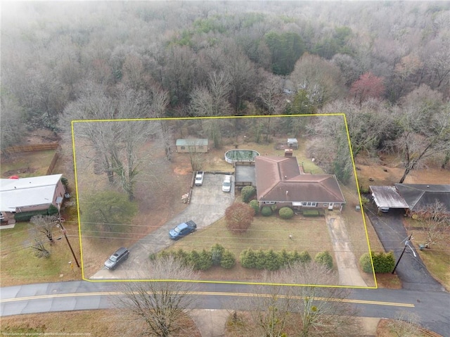 birds eye view of property featuring a forest view