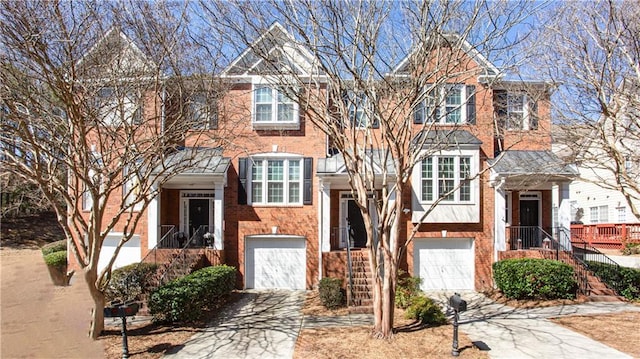 multi unit property with driveway, a garage, and brick siding