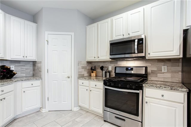 kitchen with appliances with stainless steel finishes, white cabinetry, and decorative backsplash