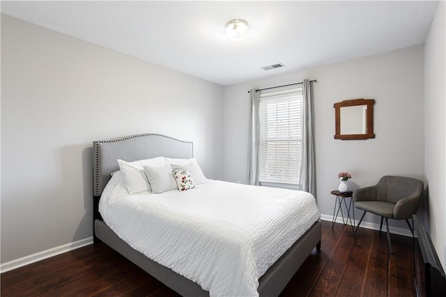 bedroom featuring hardwood / wood-style flooring, visible vents, and baseboards