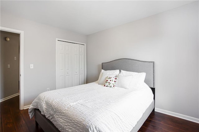 bedroom with hardwood / wood-style floors, a closet, and baseboards