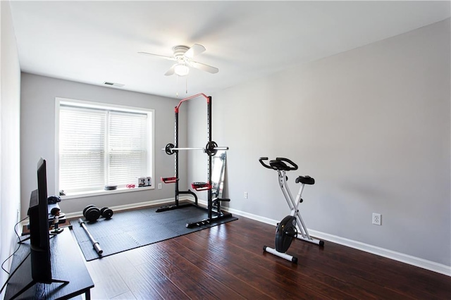 exercise room with a ceiling fan, baseboards, visible vents, and wood finished floors