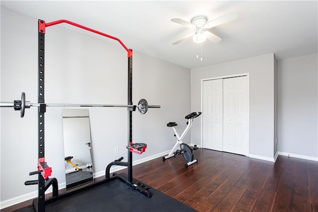 workout room featuring wood-type flooring, a ceiling fan, and baseboards