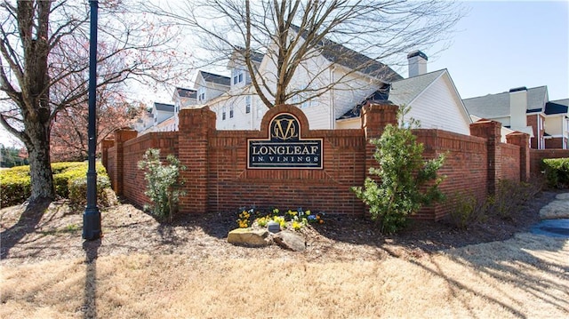 community / neighborhood sign featuring fence