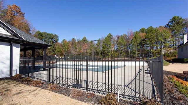 community pool with fence and a patio