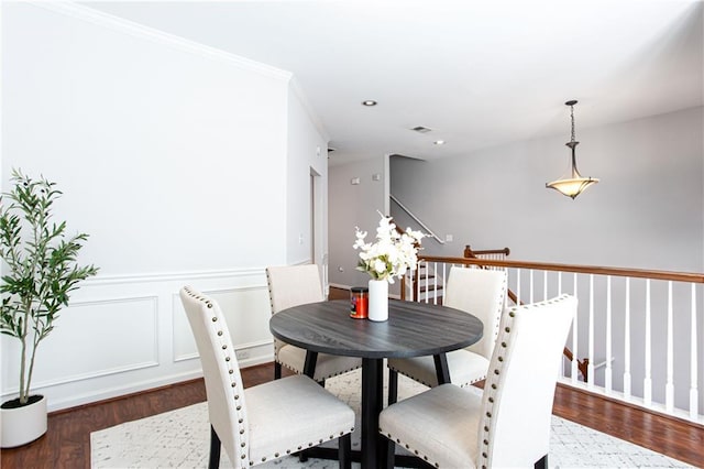 dining room with a wainscoted wall, recessed lighting, visible vents, a decorative wall, and wood finished floors