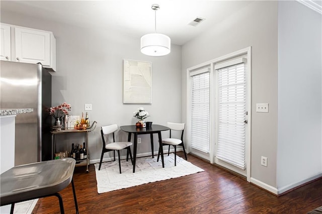 dining area featuring dark wood-style floors, baseboards, and visible vents