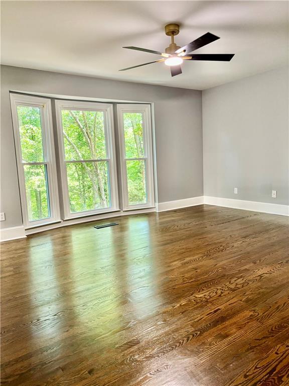 unfurnished room featuring baseboards, ceiling fan, and wood finished floors