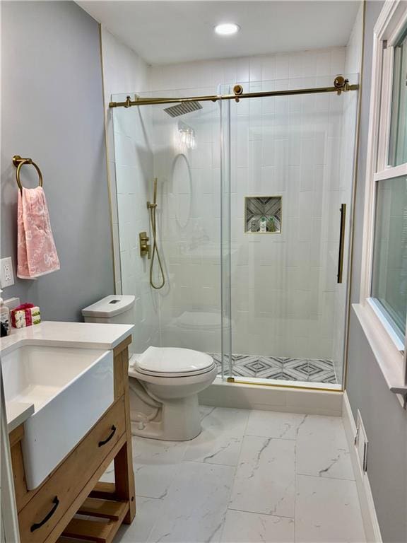 full bath featuring toilet, vanity, a shower stall, marble finish flooring, and baseboards
