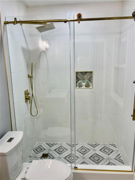 bathroom with toilet and a shower stall