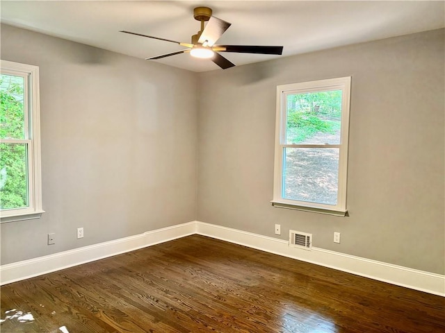 spare room featuring dark wood-style flooring, baseboards, and a ceiling fan