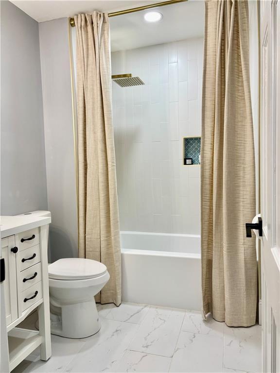 bathroom featuring marble finish floors, toilet, shower / bathtub combination with curtain, vanity, and recessed lighting