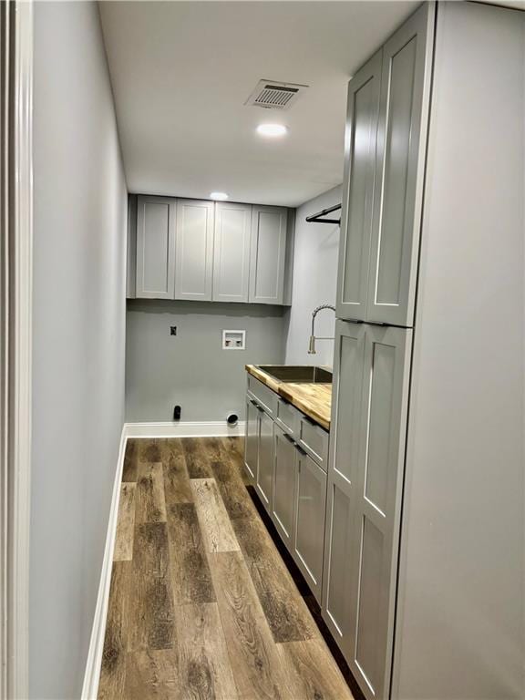 clothes washing area featuring cabinet space, washer hookup, baseboards, hookup for an electric dryer, and dark wood-type flooring