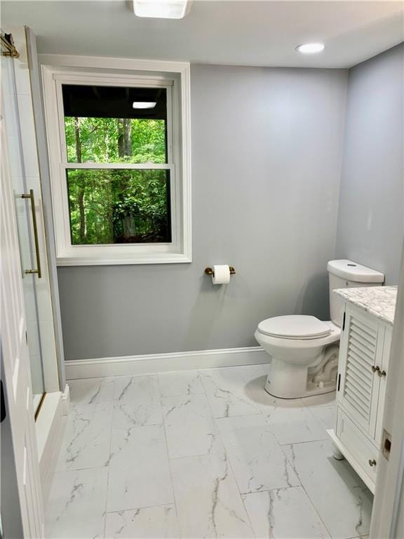 bathroom with marble look tiles, baseboards, toilet, and vanity