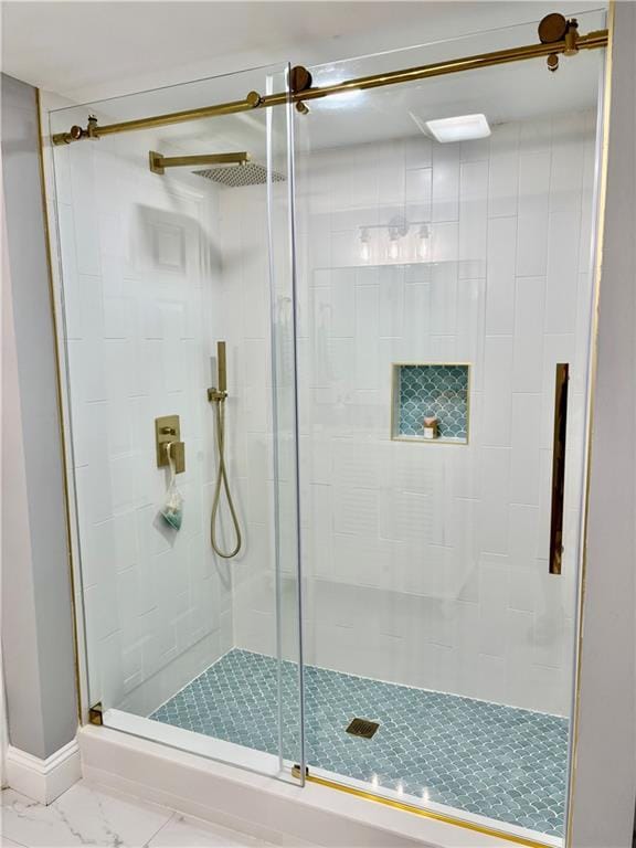 bathroom featuring a stall shower and marble finish floors