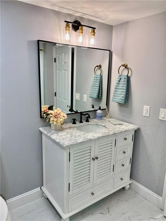 bathroom featuring marble look tile flooring, baseboards, and vanity