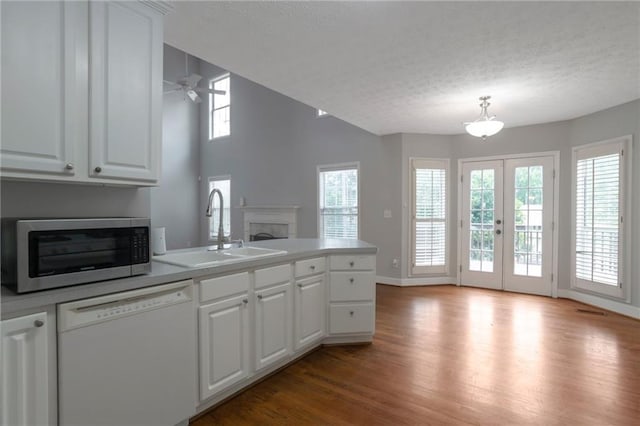 2157 Brandon Lee Dr SW, Marietta, GA 30008 - kitchen with dishwasher, a sink, stainless steel microwave, a peninsula, and light wood-style flooring