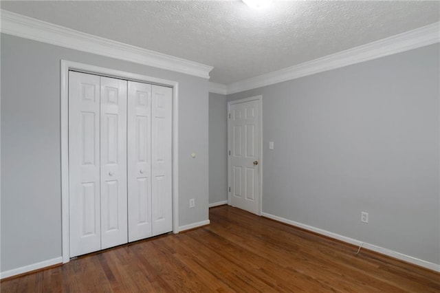 2157 Brandon Lee Dr SW, Marietta, GA 30008 - unfurnished bedroom featuring crown molding, wood finished floors, a textured ceiling, baseboards, and a closet
