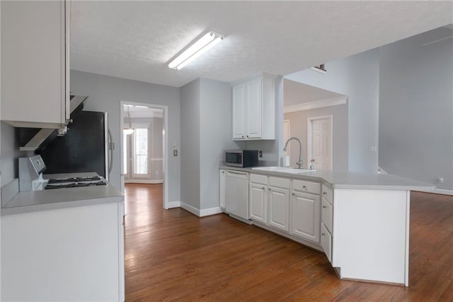 2157 Brandon Lee Dr SW, Marietta, GA 30008 - kitchen featuring stainless steel appliances, a sink, wood finished floors, a peninsula, and white cabinets