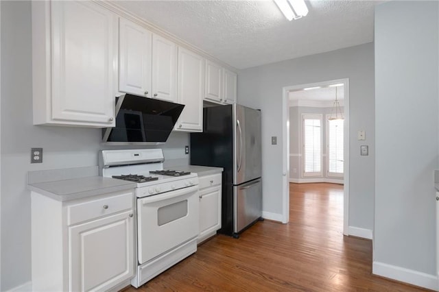 2157 Brandon Lee Dr SW, Marietta, GA 30008 - kitchen with white gas range, freestanding refrigerator, ventilation hood, wood finished floors, and white cabinets