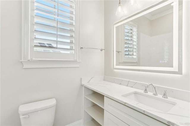 bathroom featuring a healthy amount of sunlight, toilet, and vanity