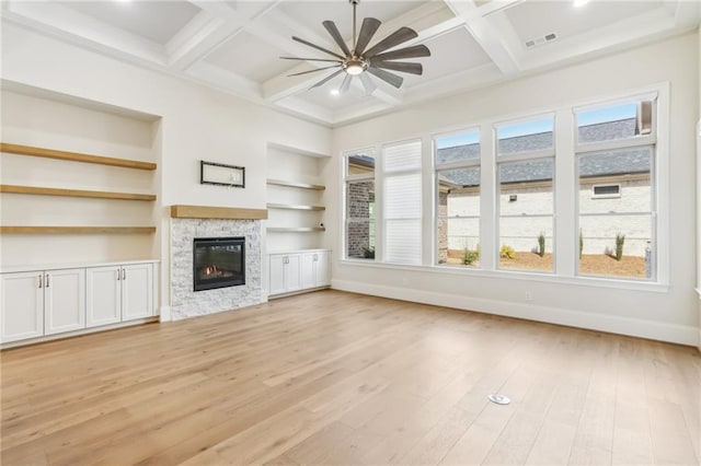 unfurnished living room featuring baseboards, visible vents, coffered ceiling, light wood-type flooring, and a fireplace