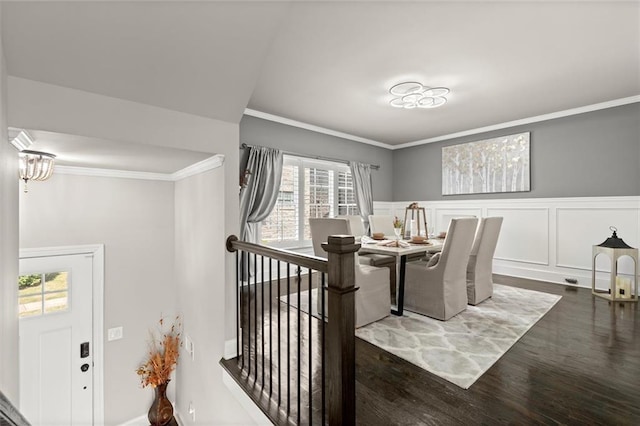 dining space with crown molding, wood finished floors, and plenty of natural light