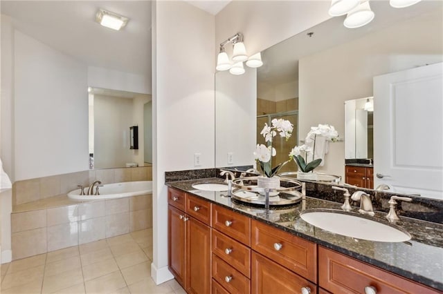 bathroom featuring vanity, a relaxing tiled tub, and tile patterned floors