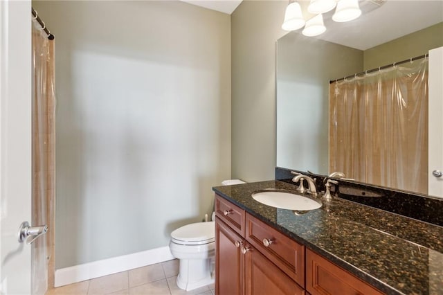 bathroom with tile patterned flooring, vanity, and toilet