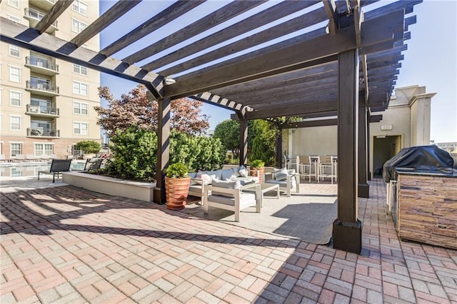 view of patio / terrace with exterior kitchen, an outdoor living space, and a pergola