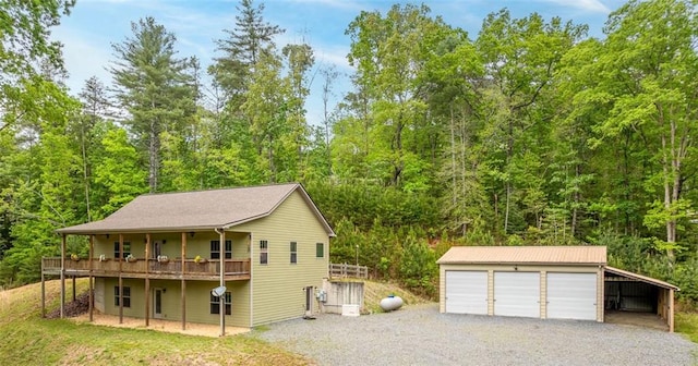 102 Waleska Ln, Ellijay, GA 30540 - view of front facade with an outbuilding, a garage, a view of trees, and a deck