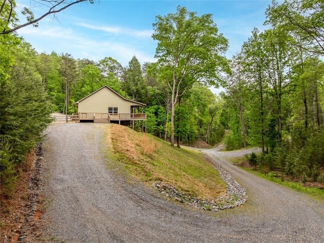 102 Waleska Ln, Ellijay, GA 30540 - view of front of home with gravel driveway, a wooden deck, and a forest view