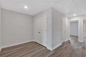 additional living space featuring baseboards and wood finished floors