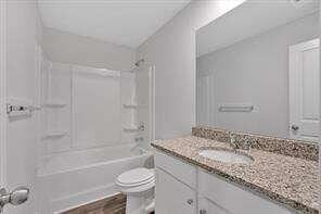 bathroom with toilet, bathtub / shower combination, and vanity