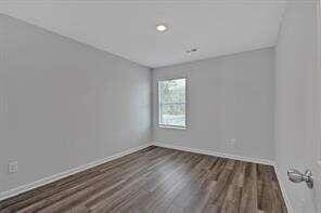 empty room featuring baseboards and wood finished floors